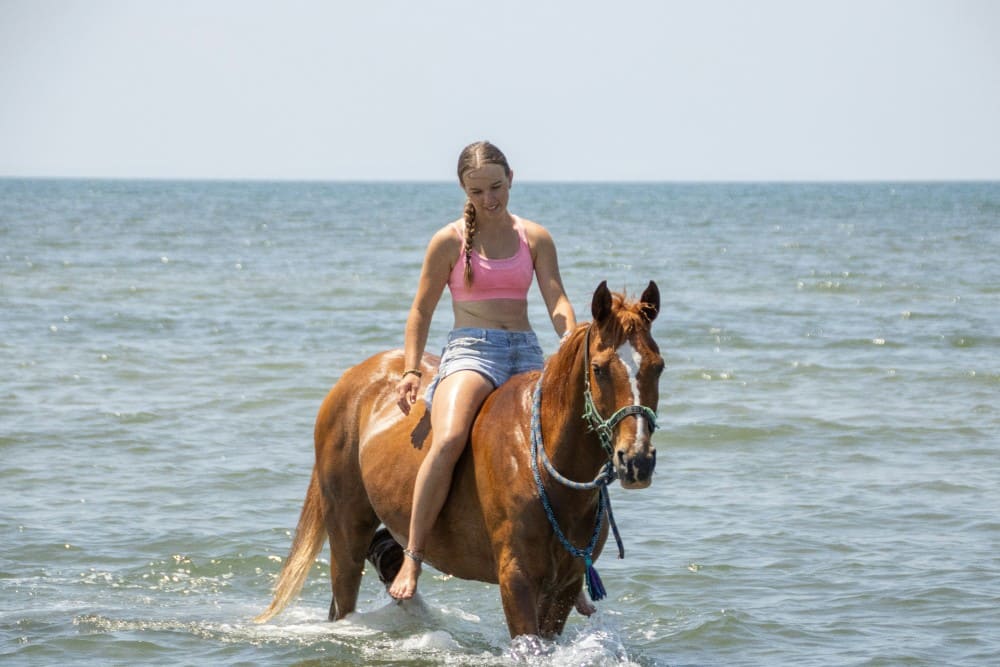 monter à cheval à cru femme en short dans l'eau